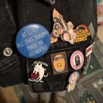 denim jacket pocket with several quirky decorate pins