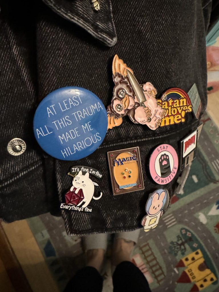 denim jacket pocket with several quirky decorate pins